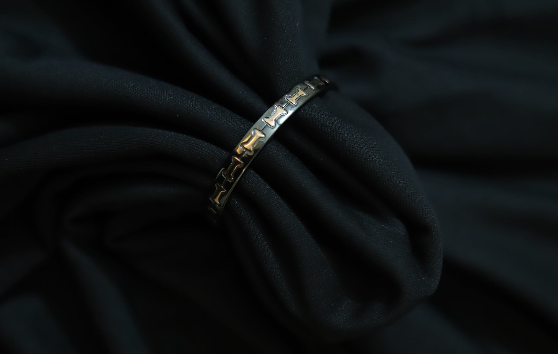 Close-up of pure silver black with rose gold bow design on a dark background