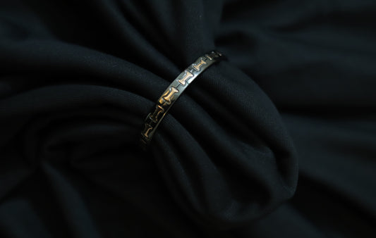 Close-up of pure silver black with rose gold bow design on a dark background