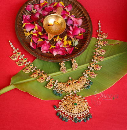Flat lay presentation of the pure silver Kaveri Gold South Necklace with green accents, resting elegantly on a textured backdrop.